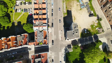 Top-down-aerial-view-of-cars-moving-along-narrow-streets-of-Old-Town-in-Gdansk-Poland,-drone-point-of-view