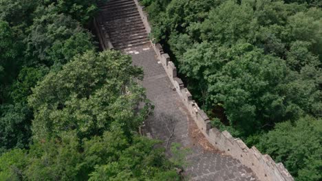 Long-and-steep-stairway-of-Great-Wall-of-China-in-between-green-trees