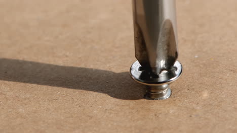 Close-up-of-screws-screwed-into-wood-with-a-screwdriver