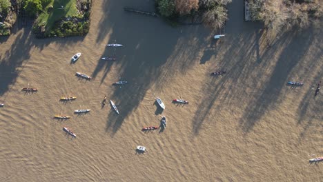 Aerial-top-down-shot-of-many-boats-cruising-on-brown-river-in-Buenos-Aires-during-sunlight