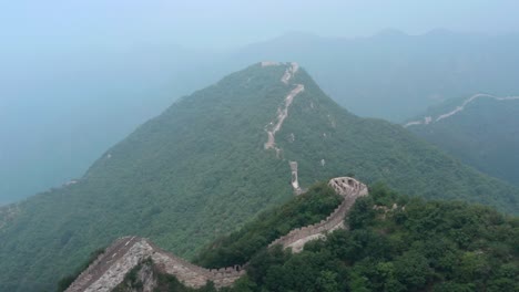 Fly-over-rural-part-of-Great-Wall-of-China-stretching-over-mountain-ridge-on-a-cloudy-day