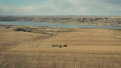 Seeding-length-of-field-at-Lake-Diefenbaker,-Canada,-aerial-wide-shot