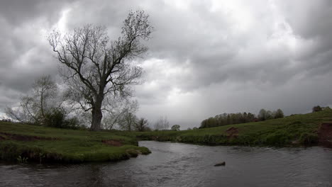 Un-Día-Frío-Y-Gris-En-El-Río-Arrow-En-Warwickshire,-Inglaterra,-Mientras-Las-Nubes-De-Lluvia-Se-Acumulan-Sobre-Esta-Escena-Rural