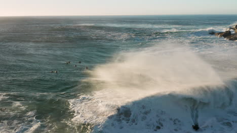 Aerial-showing-a-body-boarder-catching-a-wave-with-Sunset-in-Cape-Town,-South-Africa