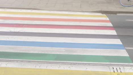 Panning-Shot-of-a-rainbow-lgbtq-pride-cross-walk-in-a-city-environment