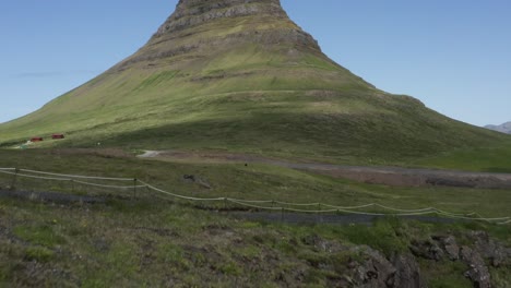 Montaña-Kirkjufell-Vista-Desde-La-Cascada-Kirkjufellsfoss,-Inclinación-Hacia-Arriba,-Antena