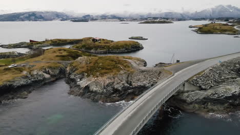 Aerial-View-Of-Car-Driving-Down-The-Atlantic-Ocean-Road-In-Norway