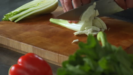 Chef-Cortando-Hinojo-En-Una-Tabla-De-Cortar-Con-La-Mano-Izquierda,verduras