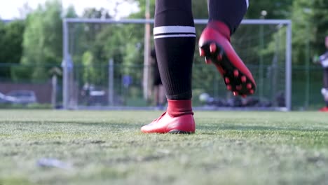 Sportlicher-Spieler,-Der-Rote-Fußballschuhe-Auf-Dem-Fußballplatz-Trägt