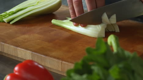 Chef-carefully-chopping-fennel,left-hand,wooden-board,vegetables