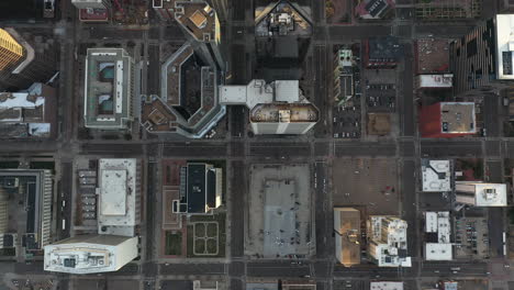 Downtown-Denver,-top-down-aerial-view,-buildings-rooftops,-parking-lots,-streets-at-evening,-cinematic-high-angle-drone-shot