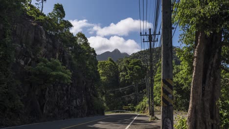 4K-Roadside-Timelapse-of-Mountainous-Terrain-on-the-Island-of-Koh-Chang-in-Thailand-with-Utility-Electrical-Poles-on-the-Side-of-the-Road-with-Moving-Vehicles
