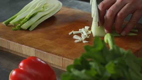 Chef-chopping-fennel-fast-on-a-wooden-chopping-board,vegetables