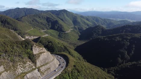 A-wide-static-shot-of-a-winding-mountain-road-with-cars-driving-on-it