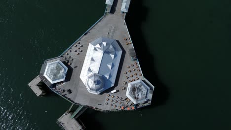 Llandudno-pier-seaside-resort-landmark-silver-pavilion-wooden-boardwalk-aerial-top-down-view