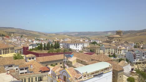 Aerial-tilt-up-reveal-view-of-the-town-o-Alhama-de-Granada-with-its-famous-church-on-the-right