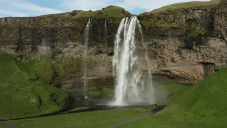 Flying-away-from-Seljalandsfoss-waterfall-revealing-Iceland-Highlands