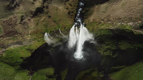 Top-down-aerial-at-flowing-waterfall-Seljalandsfoss-in-wild-volcanic-Iceland