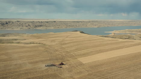 Seeding-parched-field-at-Lake-Diefenbaker,-Canada,-aerial-drone-shot
