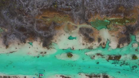 Person-relaxing-in-river-rapids-natural-hot-spring,-Bacalar-Mexico,-aerial-view