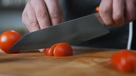 Chef-Cortando-Lentamente-Un-Tomate-Con-Un-Cuchillo-Afilado-Grande,-Verduras