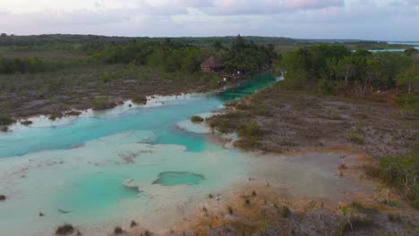 Tropical-bar-in-Mexican-lagoon-Los-Rapidos-de-Bacalar,-4K-aerial-reveal