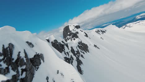 Vuelo-Rápido-A-Lo-Largo-De-La-Cresta-De-La-Montaña-Cubierta-De-Nieve,-Disparo-De-Drones-Fpv