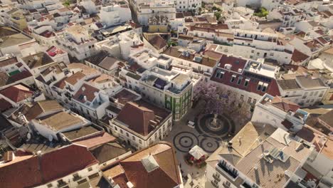 High-aerial-above-the-historic-old-town-of-Lagos,-Portugal-depicting-the-main-square-with-its-circular-pavement