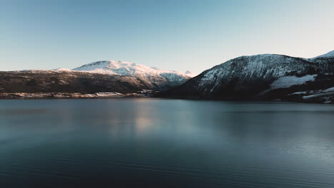Océano-Sereno-Con-Reflejo-De-Montaña-Cerca-Del-Moho-En-Noruega-Durante-El-Invierno
