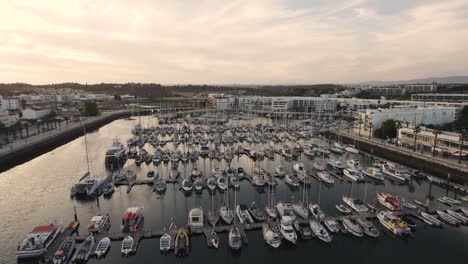 Rotating-aerial-of-tranquil-marina-full-of-boats-in-Lagos,-Portugal