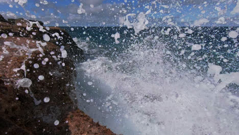 Waves-crashing-against-coastal-rocky-shoreline,-powerful-wave-erosion