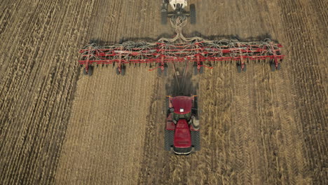 Tractor-Pulling-Seeding-Equipment-On-Field-Revealed-Lake-Scenery-In-Saskatchewan,-Canada