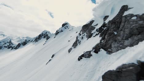 Side-flying-near-snow-covered-mountain-range,-fpv-drone-shot