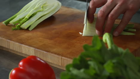 Chef-slowly-chopping-fennel-on-a-wooden-chopping-board,vegetables