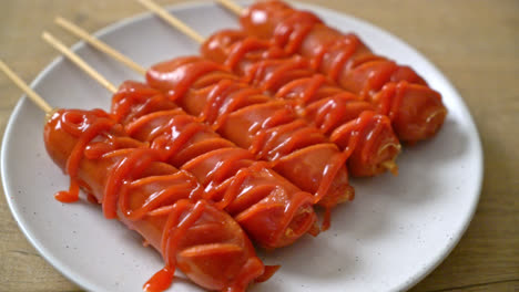 fried-sausage-skewer-with-ketchup-on-white-plate