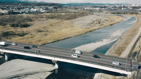 Aerial-View-Of-Traffic-Crossing-Tama-River-By-Mutsumi-Bridge-On-A-Sunny-Day-In-Tokyo,-Japan