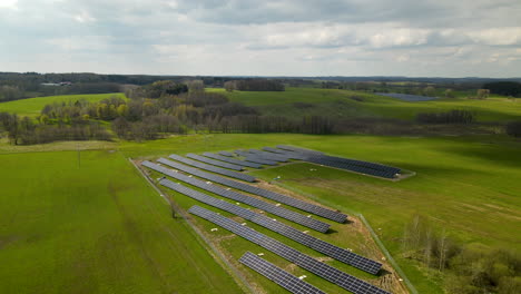 Solar-Farm-with-many-Panels-surrounded-by-agricultural-fields-in-Sunlight-and-clouds