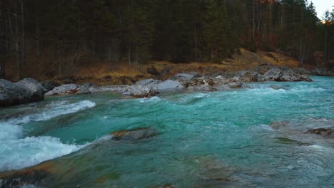 Camera-pan-of-a-scenic-and-idyllic-mountain-river-waterfall-canyon-with-fresh-blue-water-in-the-Bavarian-Austrian-alps,-flowing-down-a-beautiful-forest-along-trees-and-rocks,-perfect-for-kayak