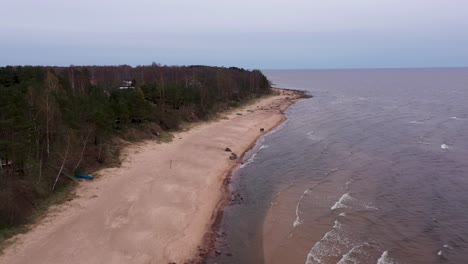 Aerial-wide-angle-flying-over-Tuja-beach-seaside,-Latvia-on-clear-sky-day