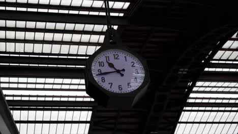 Close-up-of-a-clock-in-Milan-central-railways-station-hanging-at-vaults