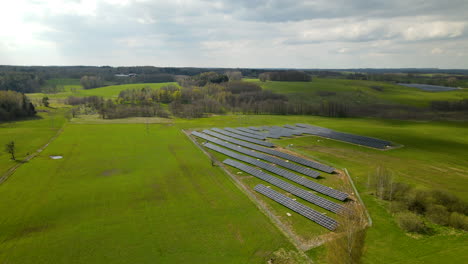 Beautiful-aerial-drone-flight-above-solar-farm-in-sunny-rural-fields-in-Poland