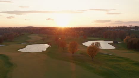 Aerial-of-golf-course-at-sunrise,-sunset