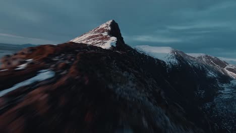 Fpv-Fliegt-Entlang-Des-Schneebedeckten-Kamms-In-Richtung-Bergspitze,-Norwegen