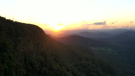 Time-lapse-aerial-shot-of-a-sunset-close-to-a-big-mountain-at-Border-Ranges-National-Park,-New-South-Wales-in-Australia