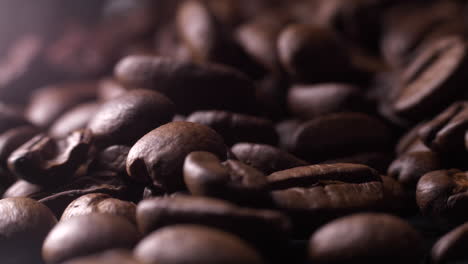 Fingers-picking-up-dark-brown-fresh-coffee-beans,-Close-up