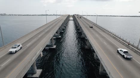Locked-down-aerial-shot-of-traffic-driving-over-a-coastal-bridge-in-Florida