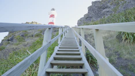 Perspective-shot-walking-up-the-steep-wooden-stairs-towards-a-lighthouse
