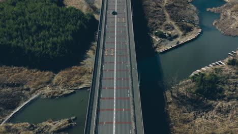 Autofahren-Entlang-Der-Brücke-Mit-Einer-Person,-Die-Am-Walteich-In-Der-Nähe-Von-Akiruno-In-Tokio,-Japan,-Fischt