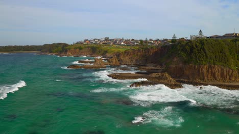 Aerial-Pullback-view-of-Sea-Stacks-With-Splashing-Waves-At-Cathedral-Rocks-Near-Coastal-Town-In-Kiama-Downs,-NSW-Australia
