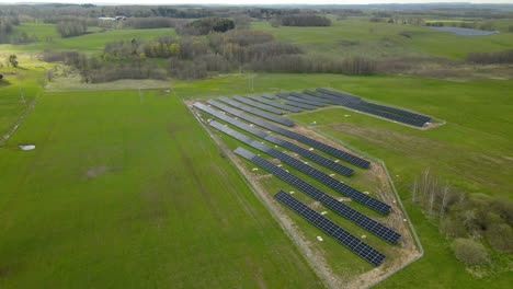 Stunning-aerial-view-of-small-solar-panels-system-on-green-field-in-Pieszkowo-Poland
